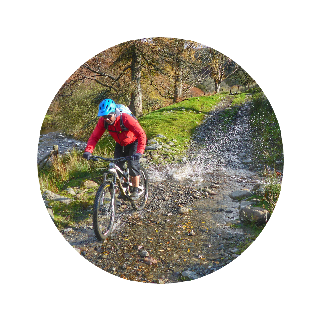 Mountain biking through a stream with corporate discounts for cycling holidays